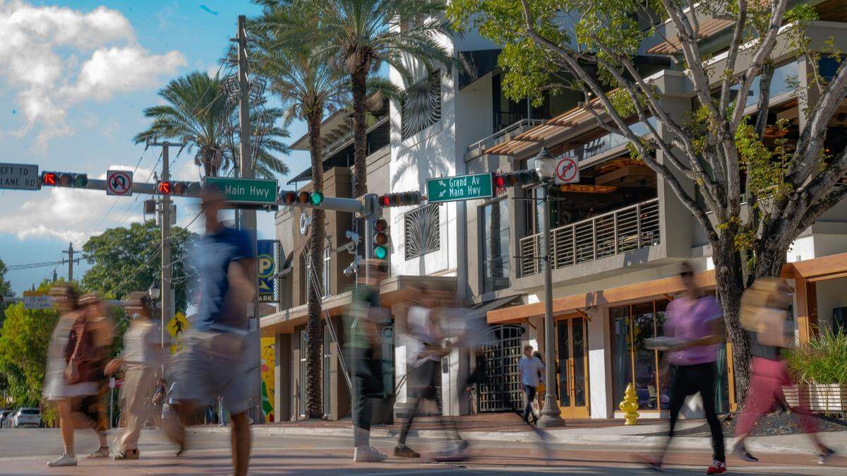 People cross Grand Avenue in Coconut Grove, where gentrification continues to wipe out its historic Black neighborhood.