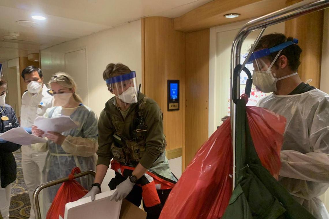 Guardian Angels, a group of medical personnel with the 129th Rescue Wing, working alongside individuals from the Centers for Disease Control and Prevention, don protective equipment on March 5, 2020, after delivering virus testing kits to the Grand Princess cruise ship off the coast of California.