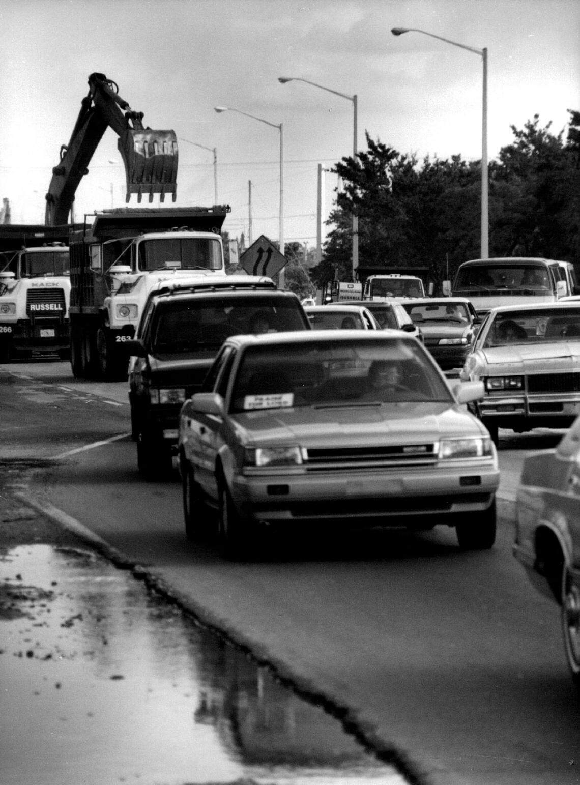 While a backhoe loads dirt and debris into dump trucks in 1993, westbound traffic backs up in the 7300 block of Pines Boulevard, along Broward Community College’s South Campus.