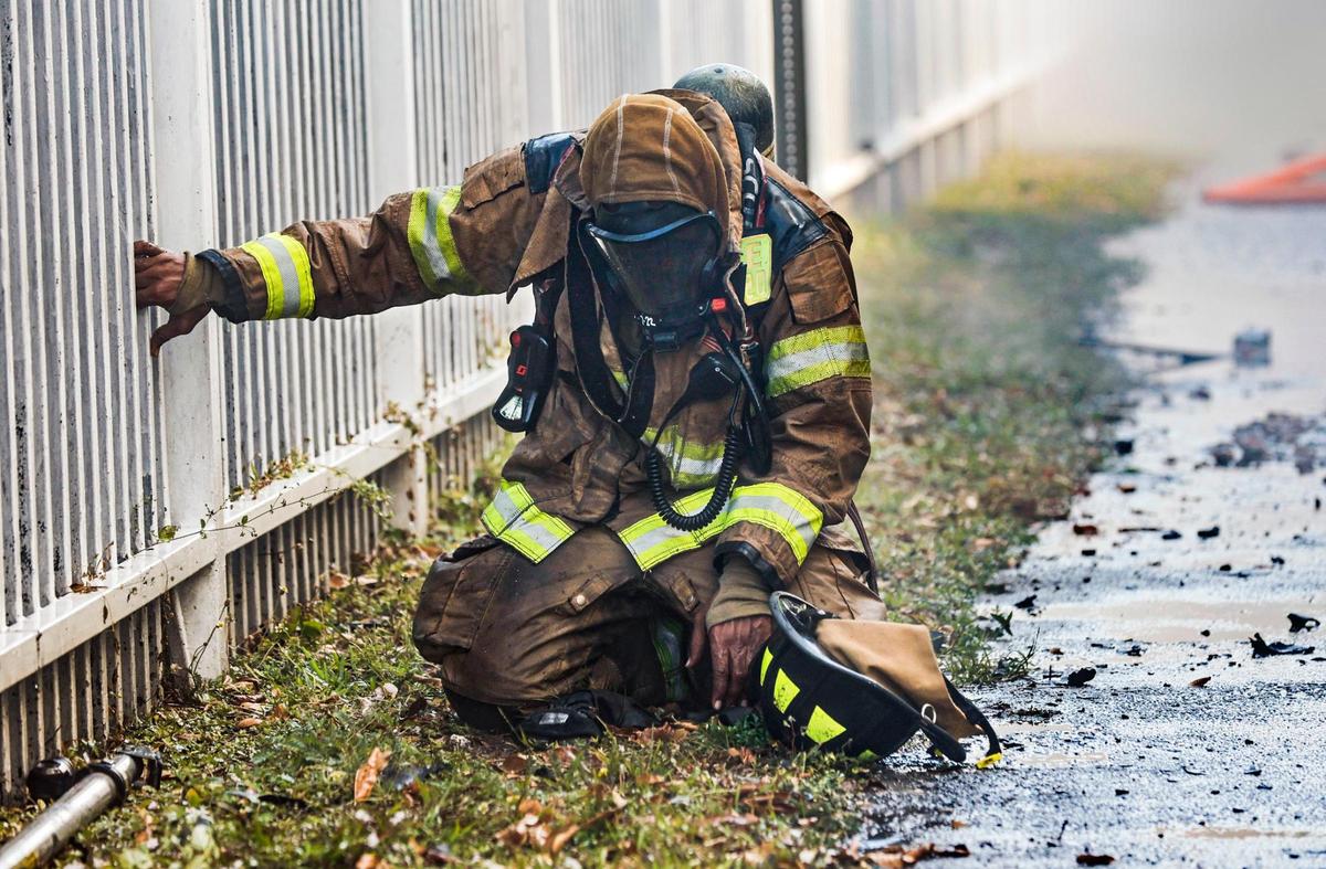 A Miami-Dade Fire Fighter rests after battling a blaze at a two-story apartment building at 395 NW 177 Street on Saturday morning, January 28, 2023.