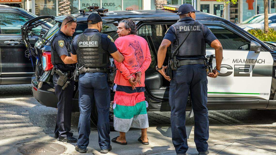 Miami Beach police take a homeless person into custody on Lincoln Road on Tuesday, March 20, 2024, hours after Florida Gov. Ron DeSantis signed a bill related to homelessness at a press conference in South Beach.
