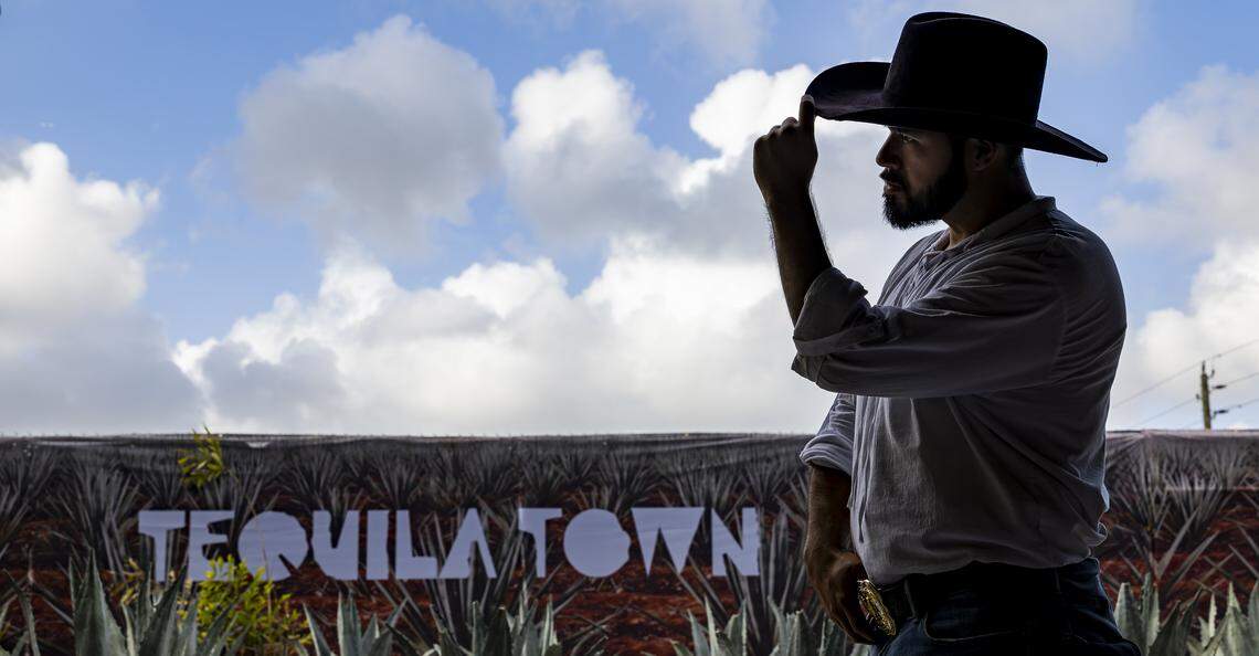 Sandro Esparza, acting as a jimador (agave harvester), looks on as guests visit Tequila Town on Friday, April 3, 2026, in Miami. Tequila Town is an immersive experience near Factory Town that takes visitors on a cinematic, multisensory journey through the history, craftsmanship, and culture of agave and tequila.
