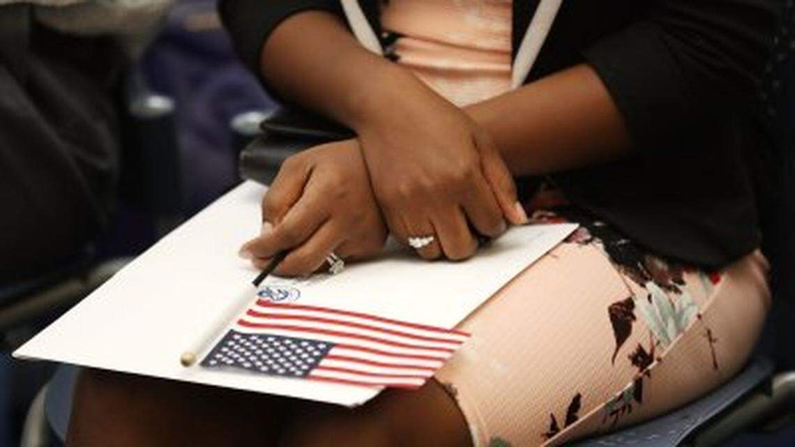 A woman on her way becoming a U.S. citizen holds an American flag during a 2018 naturalization ceremony in Miami.