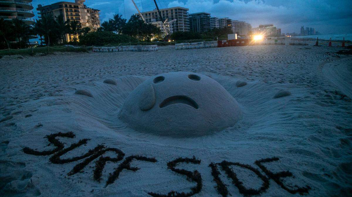 Condo buyers may soon find it difficult to secure financing, because of new regulations. Above: A sand sculpture seen near the 12-story oceanfront condo, Champlain Towers South, seven days after the building collapsed. The building has since been demolished and the site cleared.