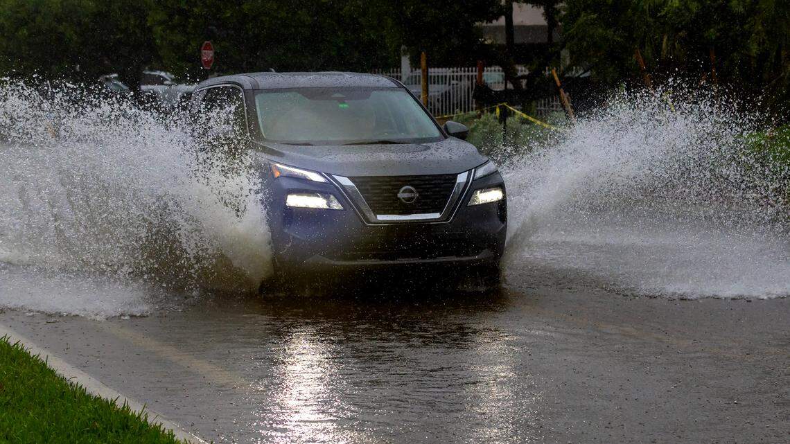A car crosses the flooded road caused by heavy rain on North Bay Rd in Sunny Isles Beach on Tuesday, June 11, 2024 in Florida.