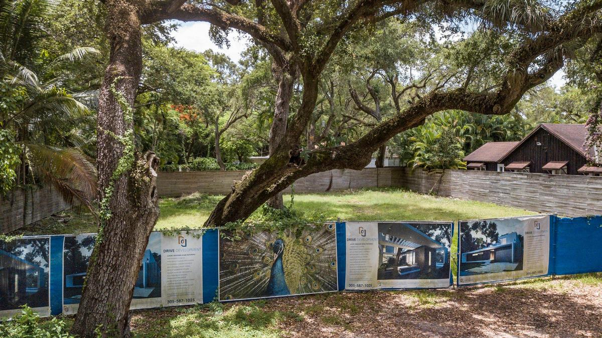 Signs of the times: Drive Development advertises a luxury designer home along a fence in the 2000 block of Secoffee Street in North Coconut Grove.