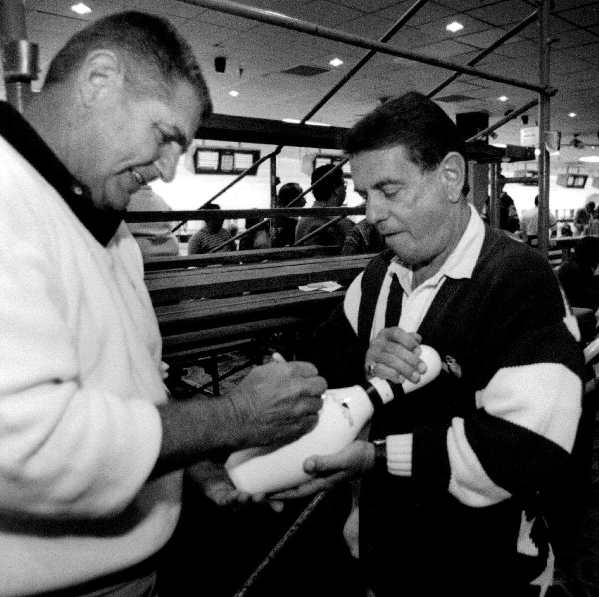 At a celebrity bowling at even at Don Carter’s Lanes in Sunrise in 1995, former Miami Dolphins quarterback Earl Morrall signs an autograph for Dick Vucenic of Lauderhill.