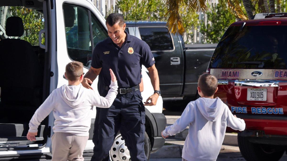 Derek, 10, left, and Devin Garcia, 8, run towards the van as Capt. Adonis Garcia, center, is greeted by them while he exits the van ahead of their father, Capt. David Garcia, as the eight Miami Beach firefighters deployed to Israel returned and were welcomed back by their families, fellow first responders, elected officials, and residents at Miami Beach Fire Station 2 on Sunday, November 19, 2023.