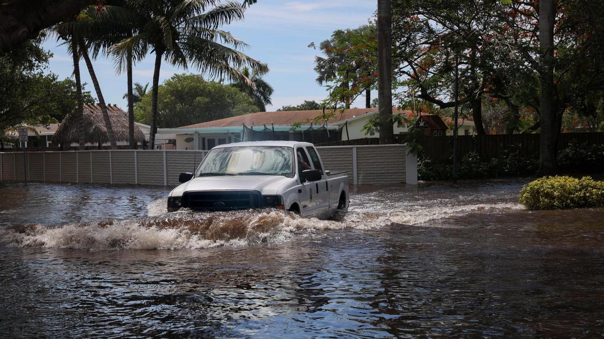 A truck turns onto Southwest 196th Street on Tuesday, June 7, 2022, in Cutler Bay following the weekend storms. Residents say the street has been flooded for days.
