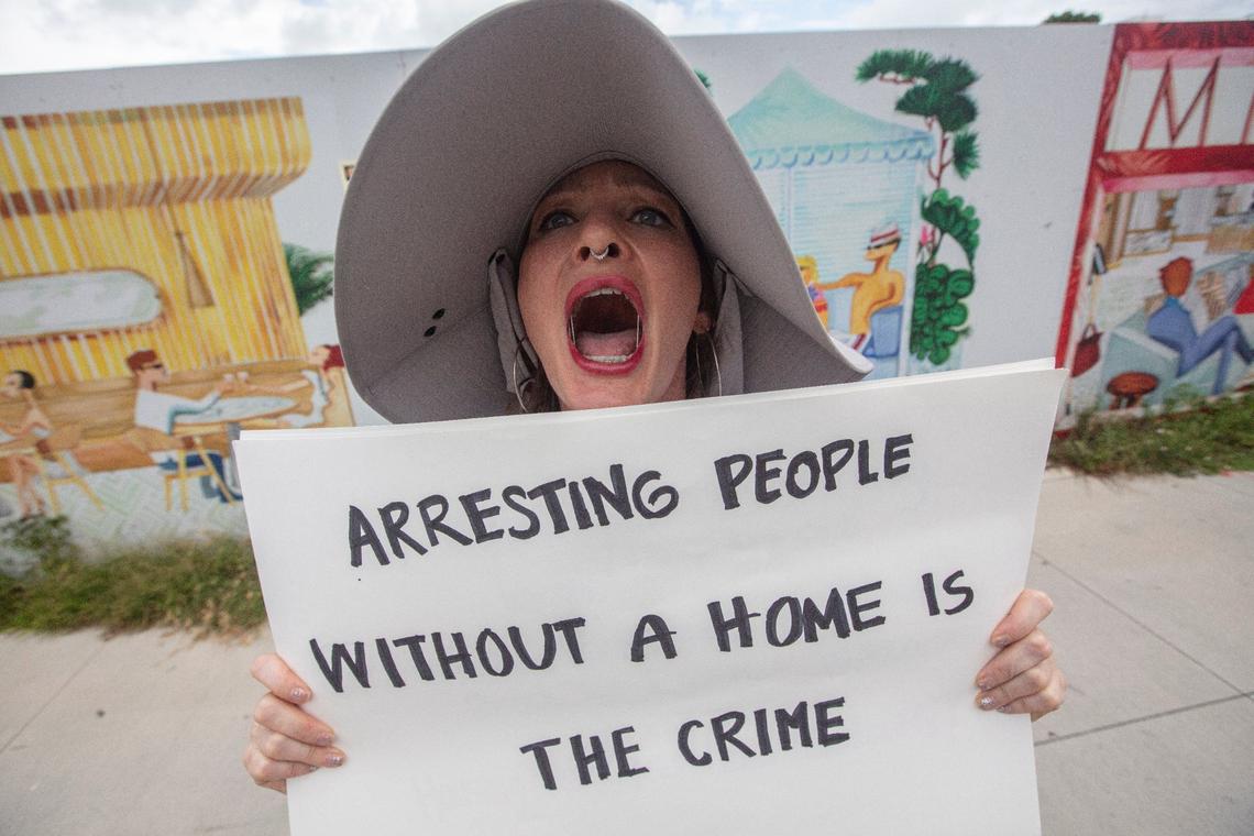 Kat Duesterhaus protests during a press conference about homelessness on Monday, July 29, 2024, at Miami Beach City Hall.