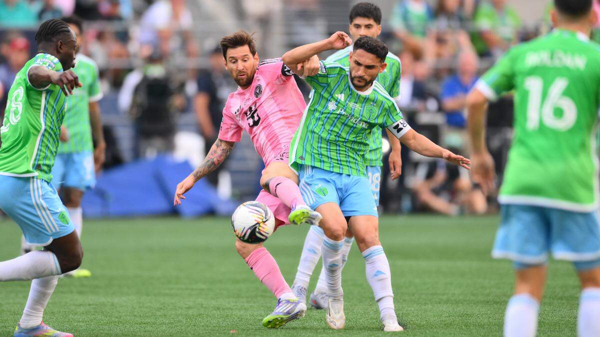 Aug 31, 2025; Seattle, Washington, USA; Inter Miami CF forward Lionel Messi (10) and Seattle Sounders FC midfielder Cristian Roldan (7) play the ball during the first half at Lumen Field. Mandatory Credit: Steven Bisig-Imagn Images