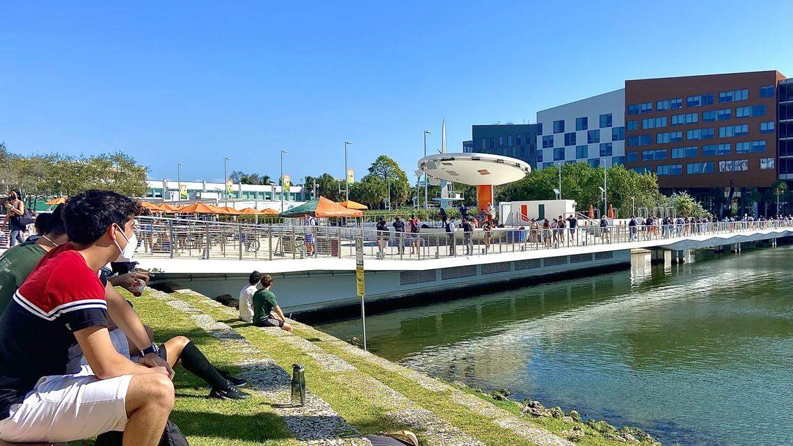 University of Miami students sit on the shore of Lake Osceola at the start of the 2021 spring semester, when masks were required outdoors.