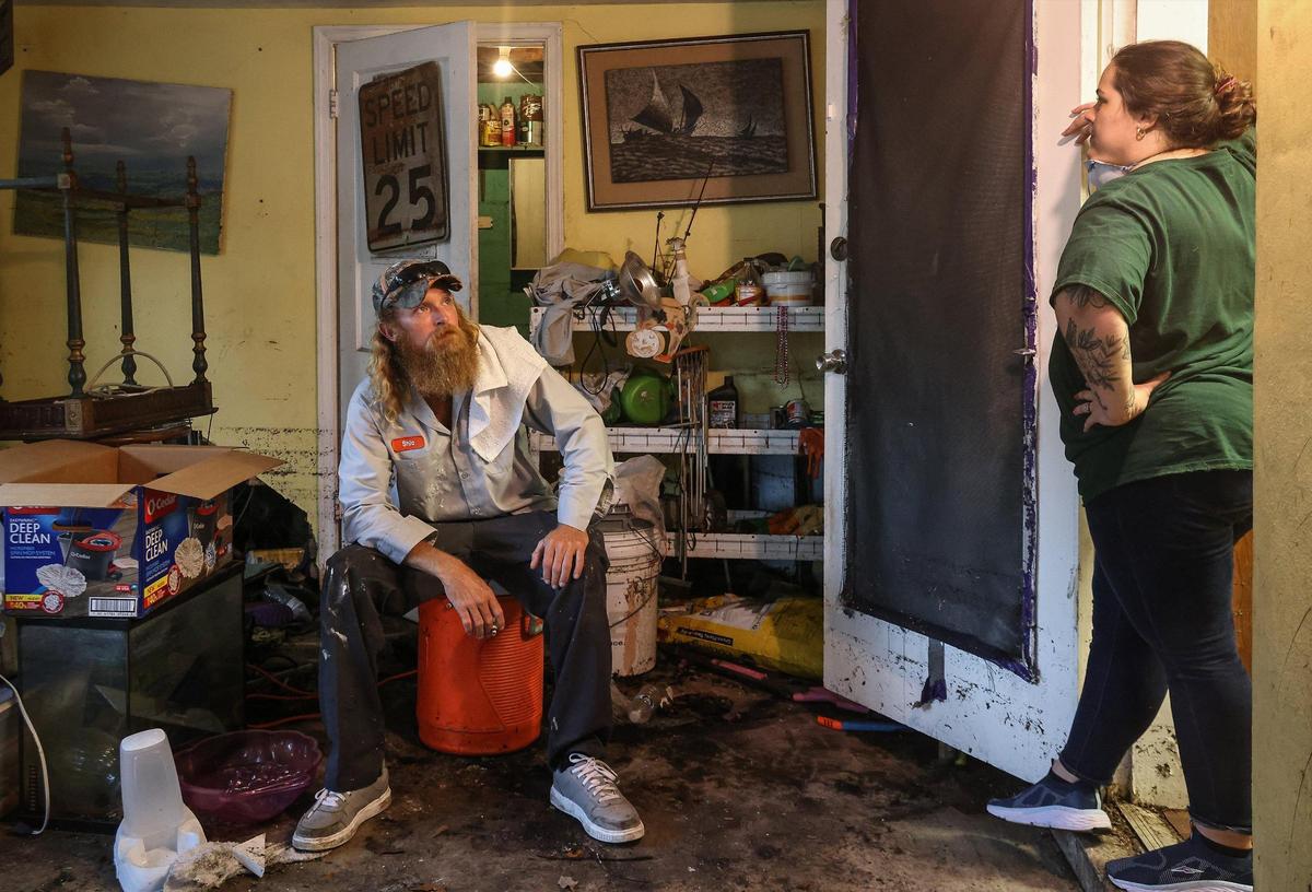 Shilo Carney, 35, left, and his wife Tara Hardy, 34, spent the day cleaning their home. The pair take a break from their clean-out after discarding the majority of their belongings. On Monday, April 17, 2023, less than a week after unrelenting rainfall flooded the streets of the Edgewood neighborhood in Fort Lauderdale, residents continued to clean out their soaked homes.