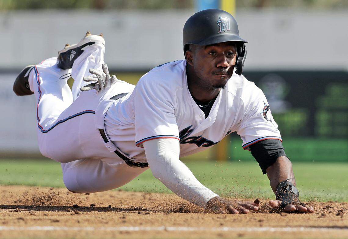 Miami Marlins’ Lewis Brinson dives into third for a stolen base during the third inning of an exhibition spring training baseball game against the St. Louis Cardinals Saturday, Feb. 23, 2019, in Jupiter, Fla. (AP Photo/Jeff Roberson)