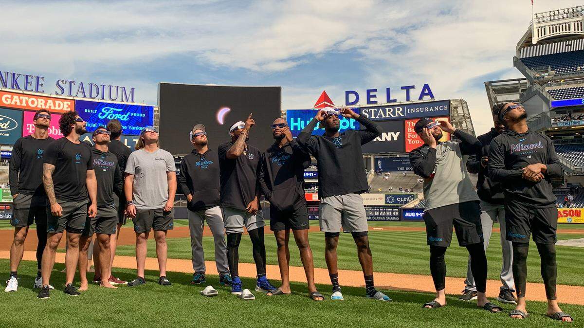 Los jugadores de los Marlins observan el eclipse solar en el Yankee Stadium en Nueva York, el 8 de abril de 2024.