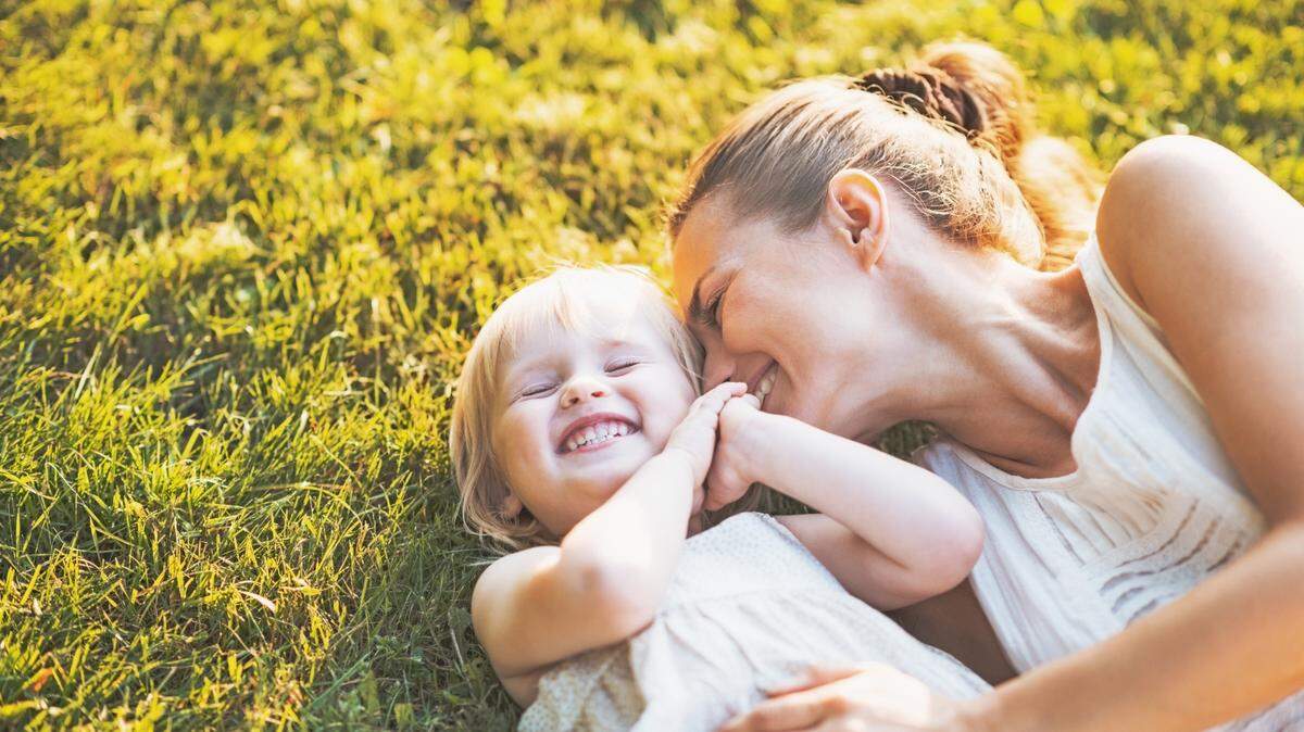 mother daughter playing in grass
