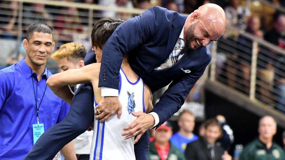 South Dade’s Bryan Morales picks up head coach Victor Balmeceda after winning the Class 3A 106-pound wrestling state championship on Saturday at Silver Spurs Arena in Kissimmee.