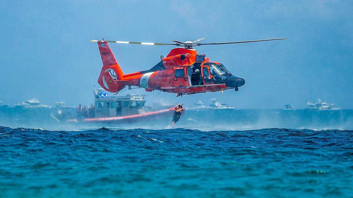 A rescue swimmer jumps to the water from a U.S Coast Guard Helicopter next to a vessel as they perform a search and rescue demonstration during the 2023 Fort Lauderdale Air Show on Saturday, April 29, 2023.
