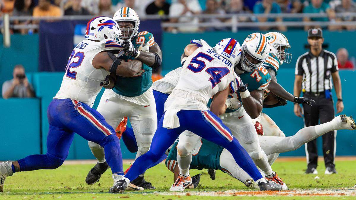 Miami Dolphins running back De’Von Achane (28) runs with the football as Dolphins guard Robert Jones (65) alongside Dolphins offensive tackle Terron Armstead (72) block Buffalo Bills linebacker Baylon Spector (54) and Bills defensive tackle DaQuan Jones (92) in the first half of their NFL game at Hard Rock Stadium on Thursday, Sept. 12, 2024, in Miami Gardens, Fla.
