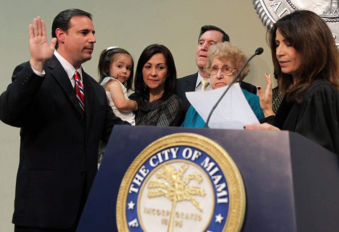 Family members joined Miami Commissioner Frank Carollo (left) as he took the oath of office during his second term swearing-in ceremony at City Hall on Nov. 15, 2013. His brother Joe Carollo is pictured third from the right.