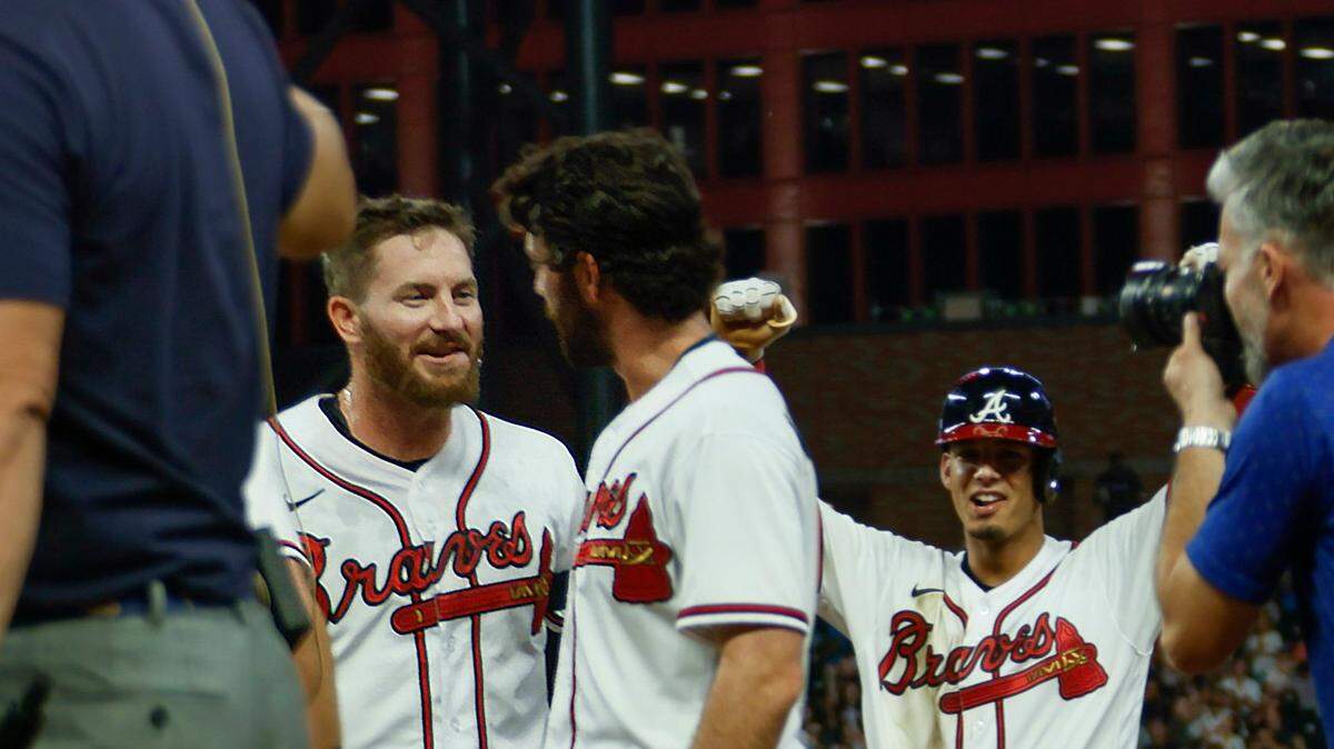 Atlanta Braves celebrate after Robbie Grossman, left, walked to score Matt Olson for the winning run in the ninth inning of a baseball game against the Miami Marlins, Saturday, Sept. 3, 2022, in Atlanta. (AP Photo/Bob Andres)