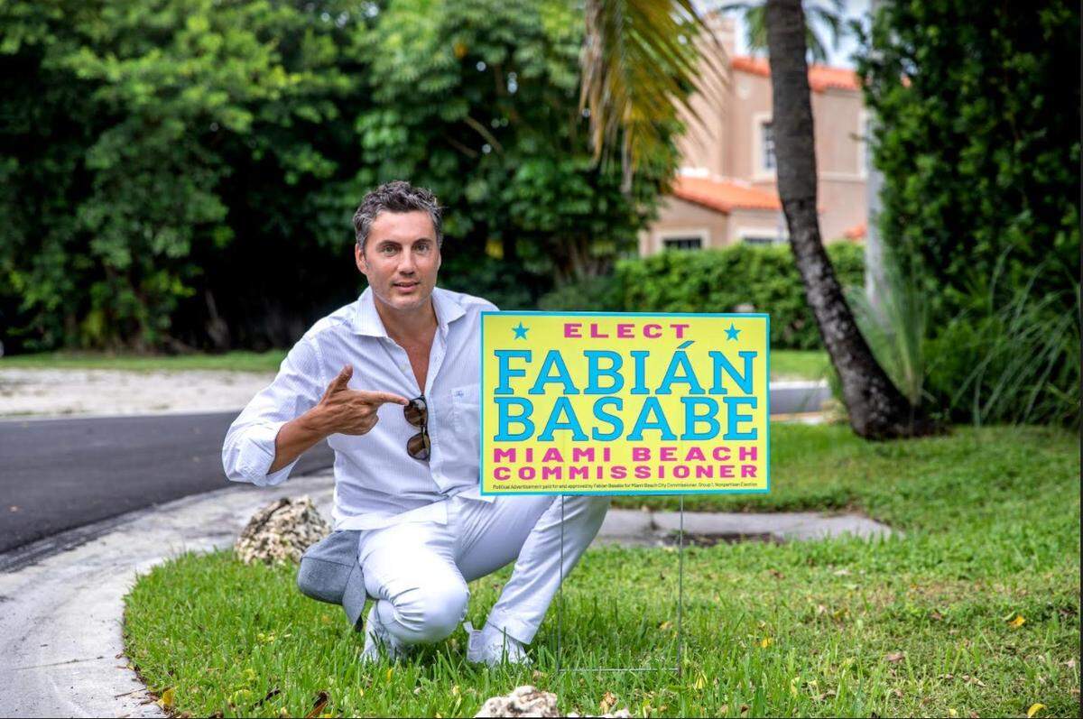Fabián Basabe posa con un cartel de campaña durante su candidatura en 2021 a la Comisión Municipal de Miami Beach, que terminó cuando un juez dictaminó que no cumplía los requisitos de residencia.