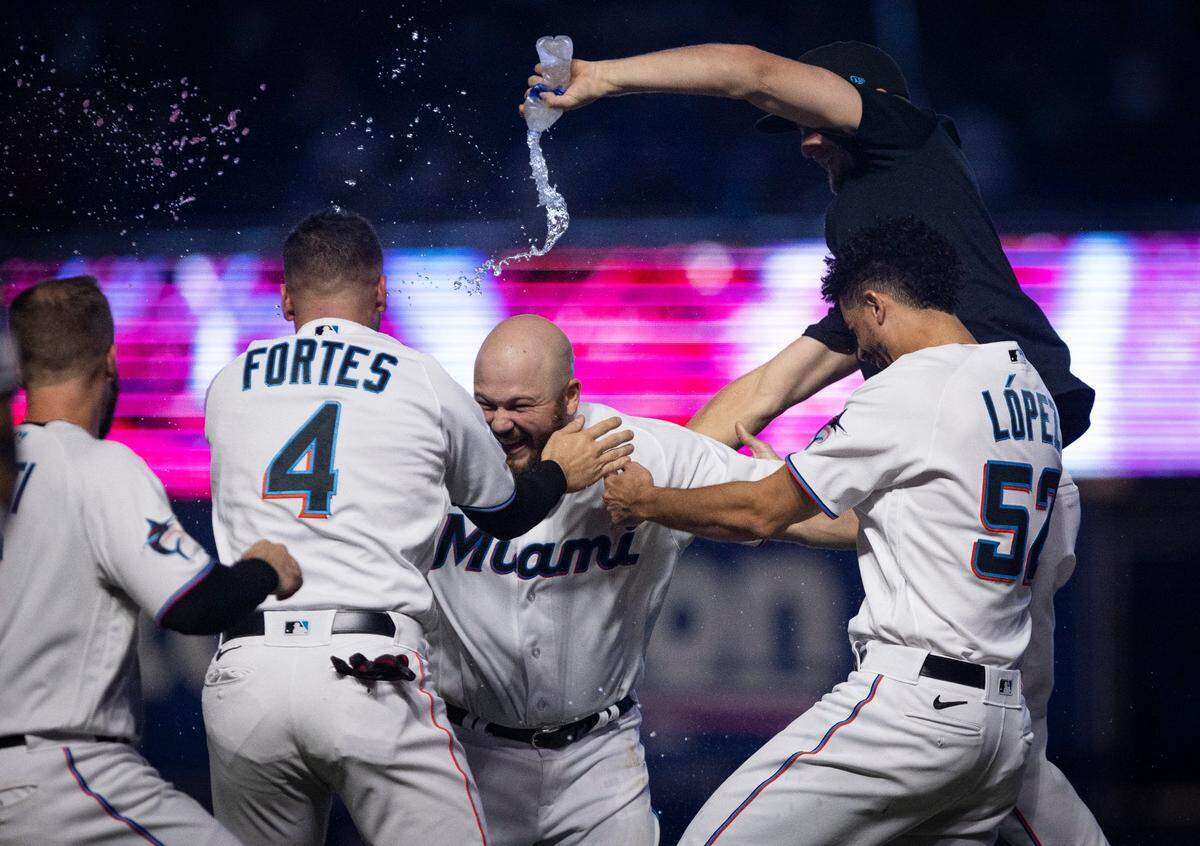 Miami Marlins third baseman Jake Burger (36) gets water dumped on him by teammates after hitting the game winning walk-off single against the New York Yankees during a baseball game on Sunday, Aug. 13, 2023, at loanDepot Park in Miami.