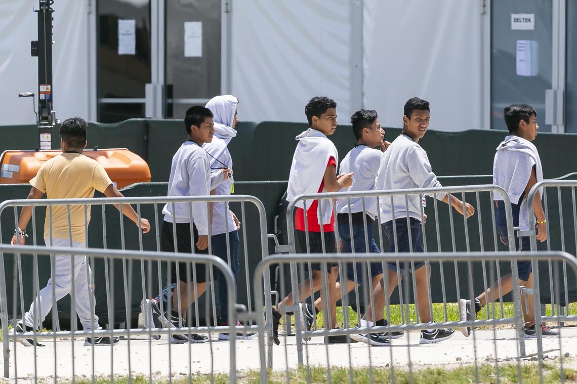 Migrant children are escorted through the Homestead Temporary Shelter for Unaccompanied Children on Good Friday, April 19, 2019.