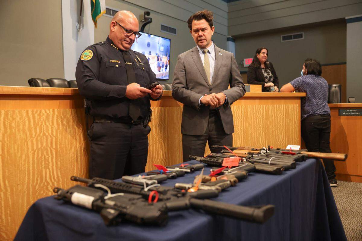 El jefe de policía de Miami, Manny Morales, a la izquierda, y el comisario Ken Russell celebran una rueda de prensa sobre el programa de recompra Guns 4 Ukraine, el martes 19 de julio de 2022, en el Ayuntamiento de Miami.