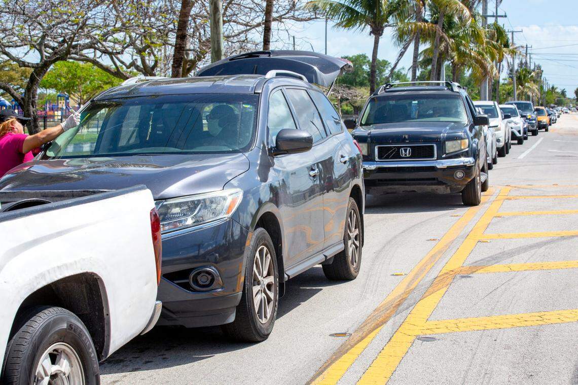 A driver speaks with a volunteer while in line to receive food benefits during a drive-thru event hosted by Farm Share, a nonprofit, at Goulds Park on March 20. “While our real estate community is climbing back, thousands of our neighbors remain rooted in crippling unemployment, impossible financial challenges, and of greatest concern, rising food insecurity,” says Master Brokers Forum member board member Andres Asion, who is the founder/broker of the Miami Real Estate Group.