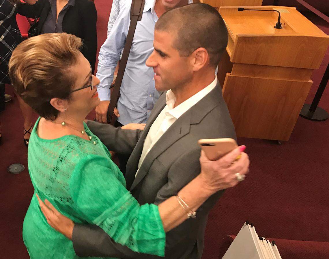 Miami-Dade Commissioner Rebeca Sosa hugs Frankie Ruiz, a leading Miami runner, after a commission vote to spend $25 million buying a five-mile abandoned railway. Miami-Dade plans to convert the land to the Ludlam Trail park, a hiking and biking trail.