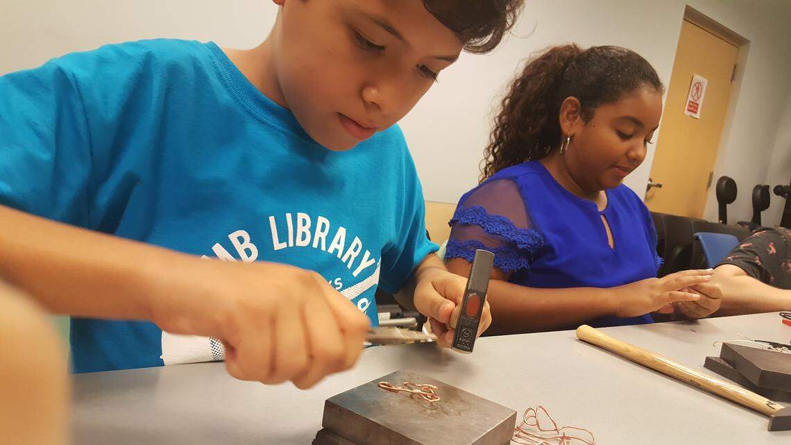 Antoinio Telaya and Mia Presuot work on their wire jewelry at the North Miami Beach library. Jewelry Creations Workshop, an artist workspace and jewelry school in North Miami, hosted the Young Metal Artist class July 3 led by Studio Manager Tracey Carswell.