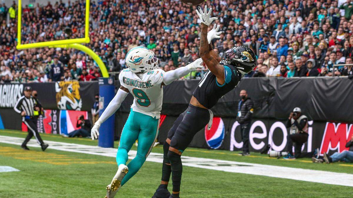 Jacksonville Jaguars wide receiver Marvin Jones Jr. (11) catches a pass for a touchdown defended by Miami Dolphins cornerback Noah Igbinoghene (9) near the end of the first half of an NFL football game at Tottenham Hotspur Stadium in London, Sunday, Oct. 17, 2021. (AP Photo/Gary McCullough)