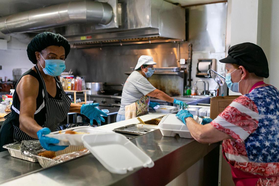 From left to right: Volunteers Pat Lane, 68, Karen Browning, 65, and Maria ‘Mama’ Vigil, 74, prepare food minutes before serving them to their community at Homestead Soup Kitchen in Homestead, Florida on Friday, June 26, 2020.