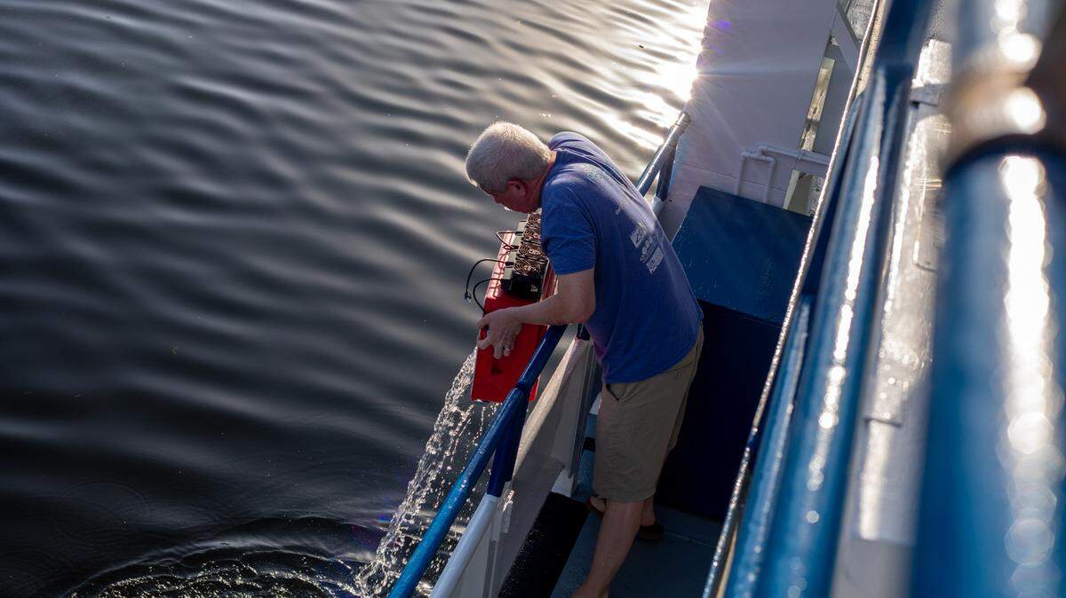On the Miami River, Mark Schick, the senior director of animal operations on the Coral Reef II research vessel owned by Shedd aquarium, dumps water overboard.