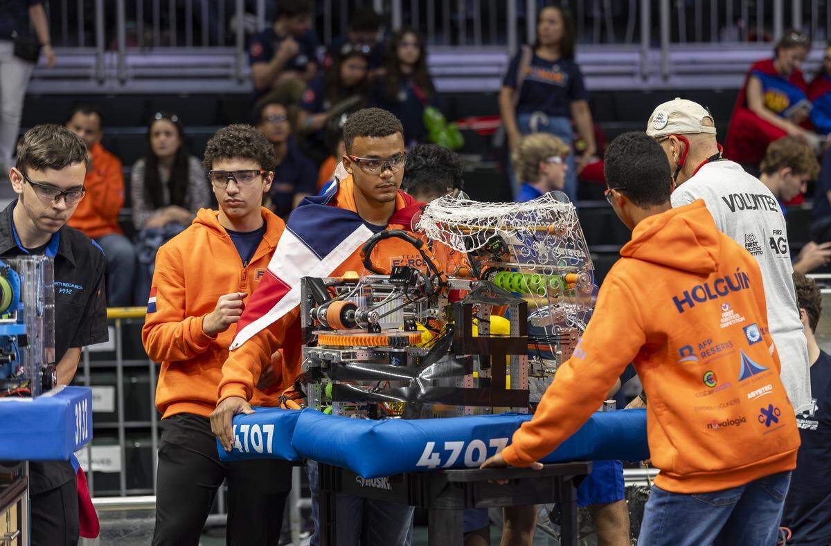 Student Ranfi Serra Guzman, 17, center, a member of Team Force from Comunidad Educativa Lux Mundi in the Dominican Republic, pushes his team’s robot as they compete in the 2026 FIRST Robotics South Florida Regional Competition at the University of Miami’s Watsco Center on Friday, April 10, 2026, in Coral Gables, Fla. Participants from local school districts, surrounding states, and international teams are competing for an opportunity to earn a spot at the 2026 FIRST World Championship.