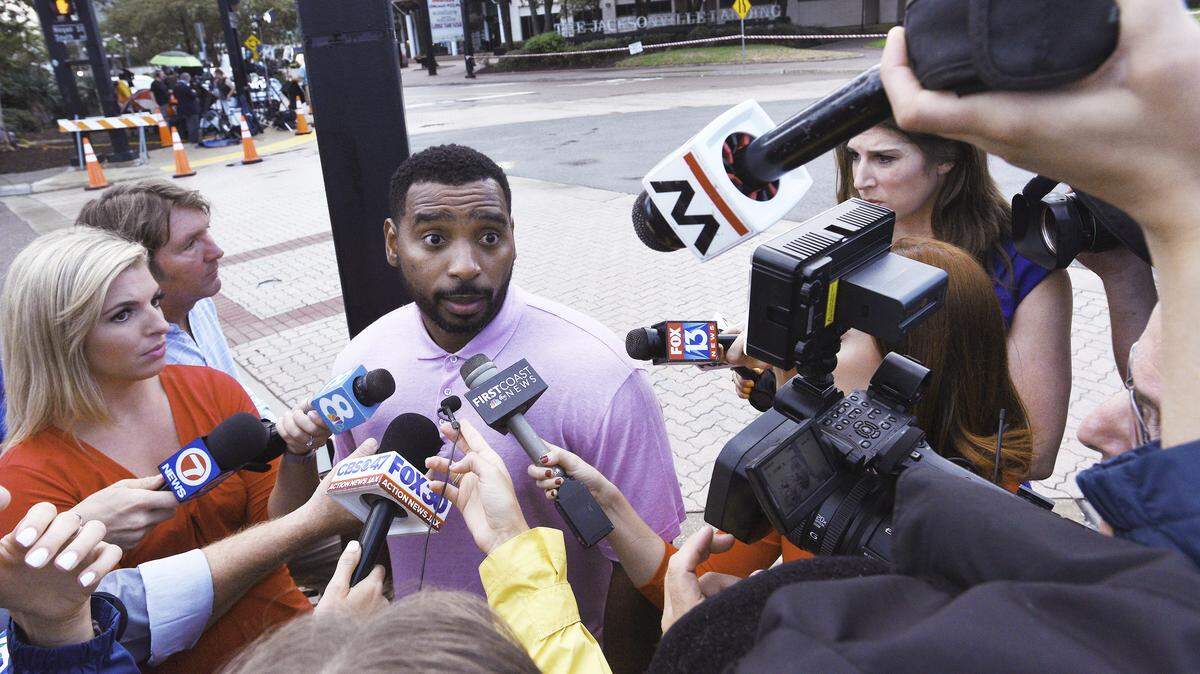 Toshiba Sharon, an announcer for the video game tournament from Philadelphia, talks to members of the media Monday about what he saw during Sunday’s mass shooting across the street from the Jacksonville Landing in downtown Jacksonville.