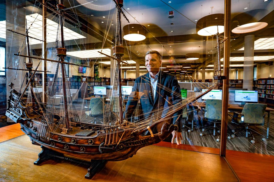 Miami-Dade Public Library System Director Ray Baker looks over the 1930 model of a 17th century Spanish Galleon at Coral Gables Branch Library. The model sits on the table city founder George Merrick originated the plans for the development of the City of Coral Gables. The library plans to reopen on Monday, May 22 after closing for renovations in 2021 with all new lighting, computers, and furnishings.