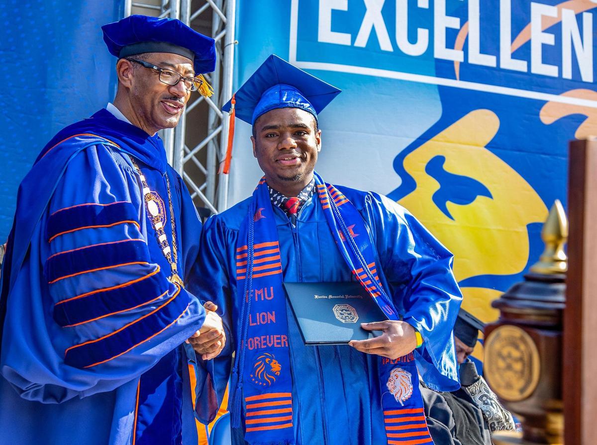 President Jaffus Hardrick poses for a photo shaking the hand of aviation graduate Mathew Brown during the spring commencement ceremony at Florida Memorial University in Miami Gardens, on Saturday May 6, 2023.