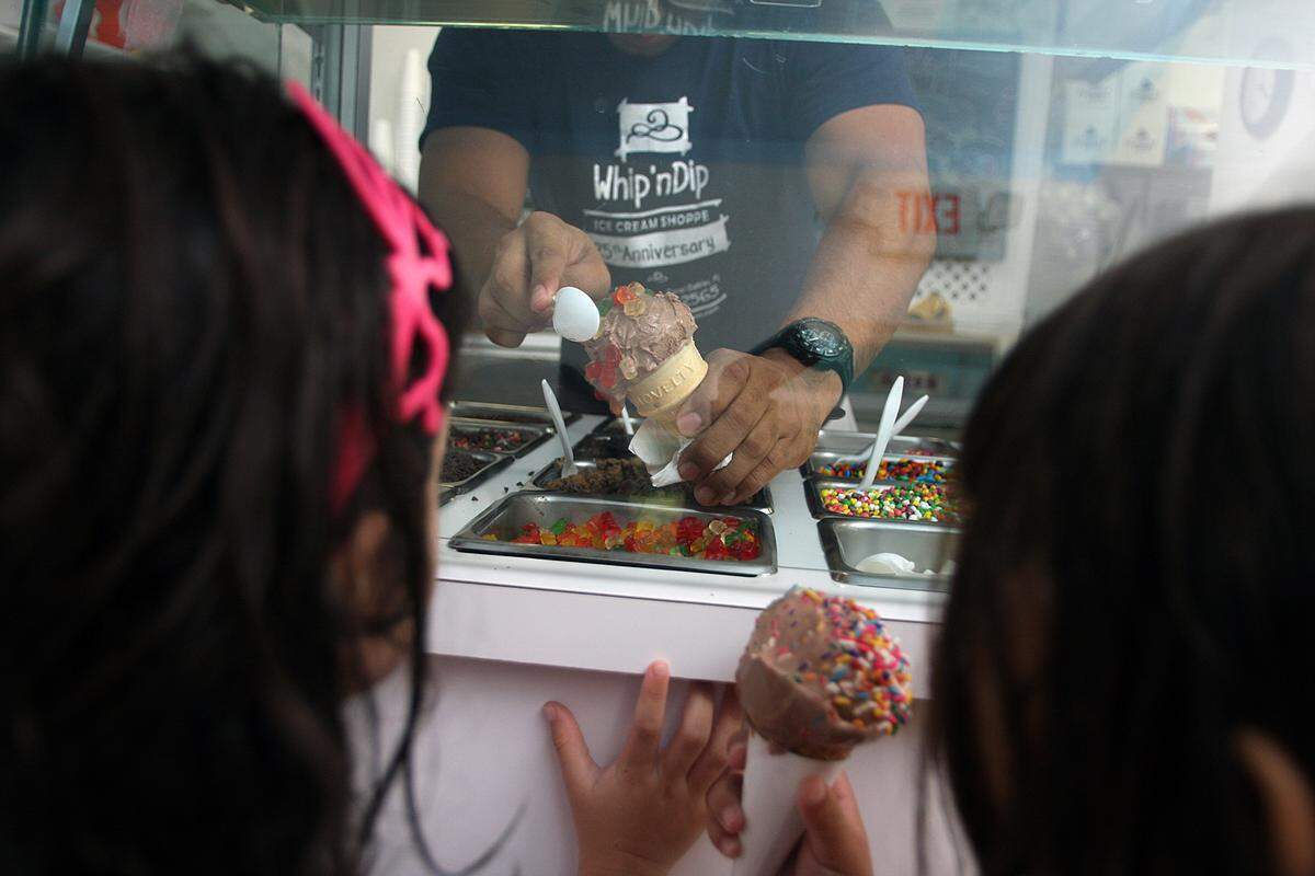 Ava Garcia watches with her friend Nicolette Penaranda, both age 4, as her chocolate ice cream in a cone is dipped in gummie bears at Whip ‘N Dip Ice Cream Shoppe on Wednesday, June 2, 2010.