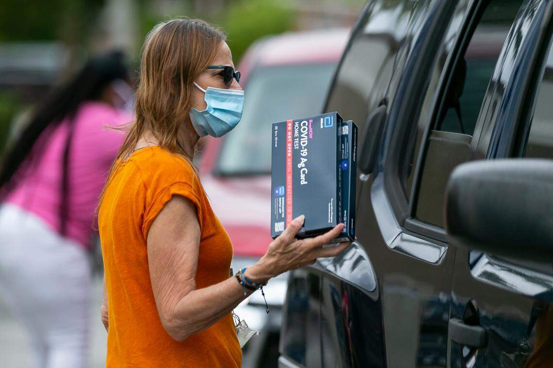 Patty, a Broward County employee, hands out free at-home rapid COVID-19 tests at Margate Catherine Young Library in Margate, Florida, on Saturday, Jan. 8, 2022.
