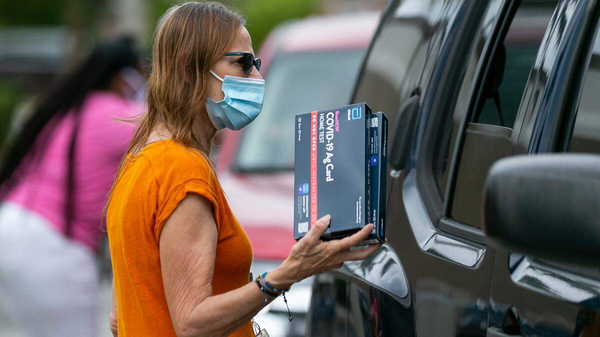 Patty, empleada del Condado Broward, entrega pruebas rápidas gratis del COVID-19 en la Biblioteca Catherine Young en Margate, Florida, el sábado 8 de enero de 2022. MATIAS J. OCNER MOCNER@MIAMIHERALD.COM