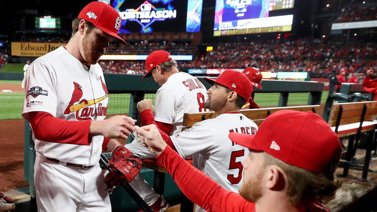 Miles Mikolas high-fives his teammates in the dugout after closing out the top of the first inning against the Washington Nationals in Game 1 of the National League Championship Series at Busch Stadium on Oct. 11, 2019 in St Louis, Missouri. His 2019 season for the St. Louis Cardinals, which included a 1.50 ERA and a 1-1 record in the playoffs, culminated Tuesday with his induction into the Nova Southeastern University Athletics Hall of Fame.