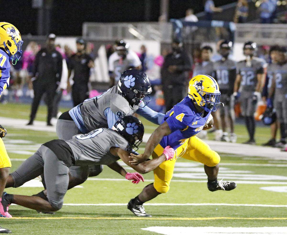 Northwestern Bulls running back Irvin James (4) tries to escape a tackle by Palmetto defenders during football game on Friday, October 17, 2025 at Traz Powell Stadium in Miami. Andrew Uloza / for Miami Herald