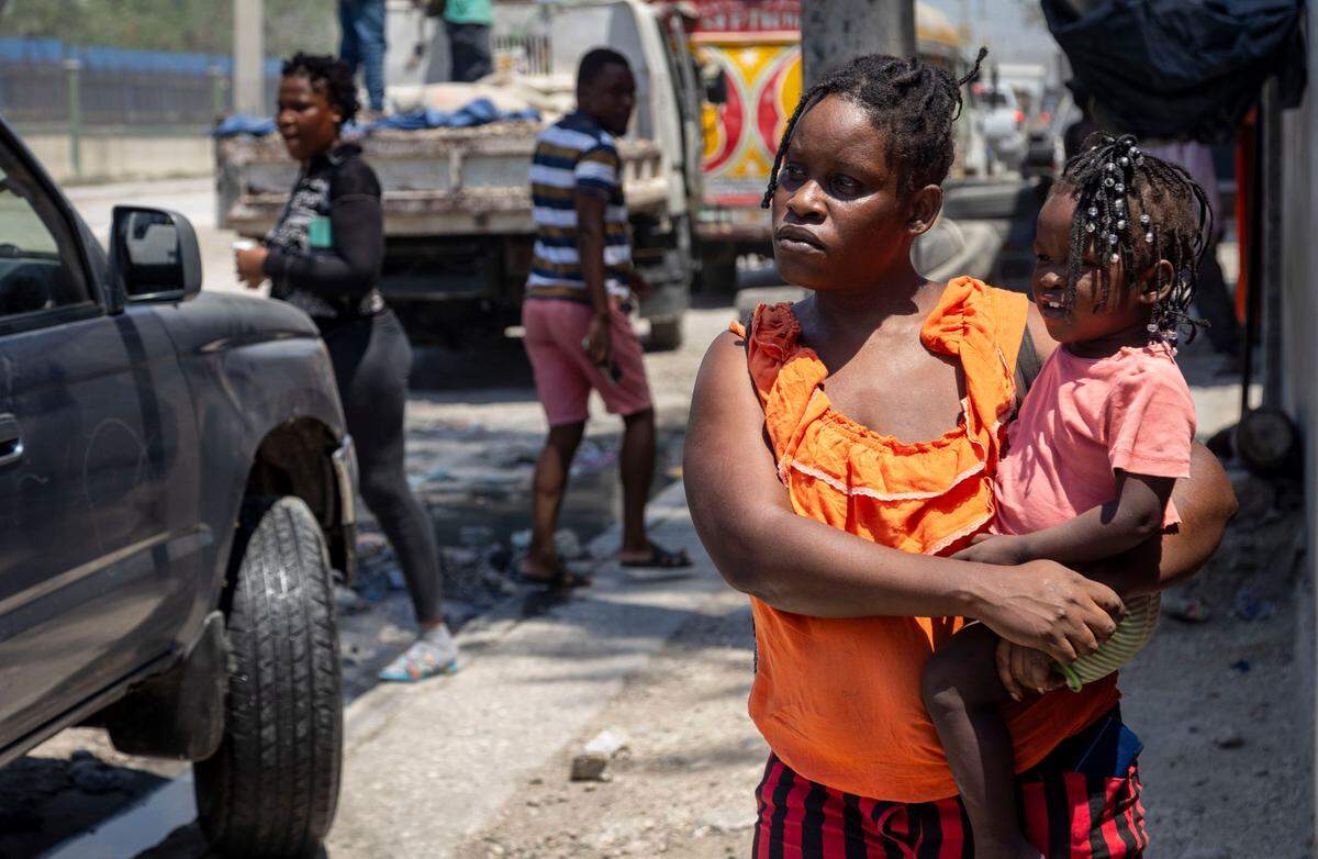 A woman holds her baby at a displacement camp in Port-au-Prince, Haiti, for people who have been forced to flee their homes by gang violence.