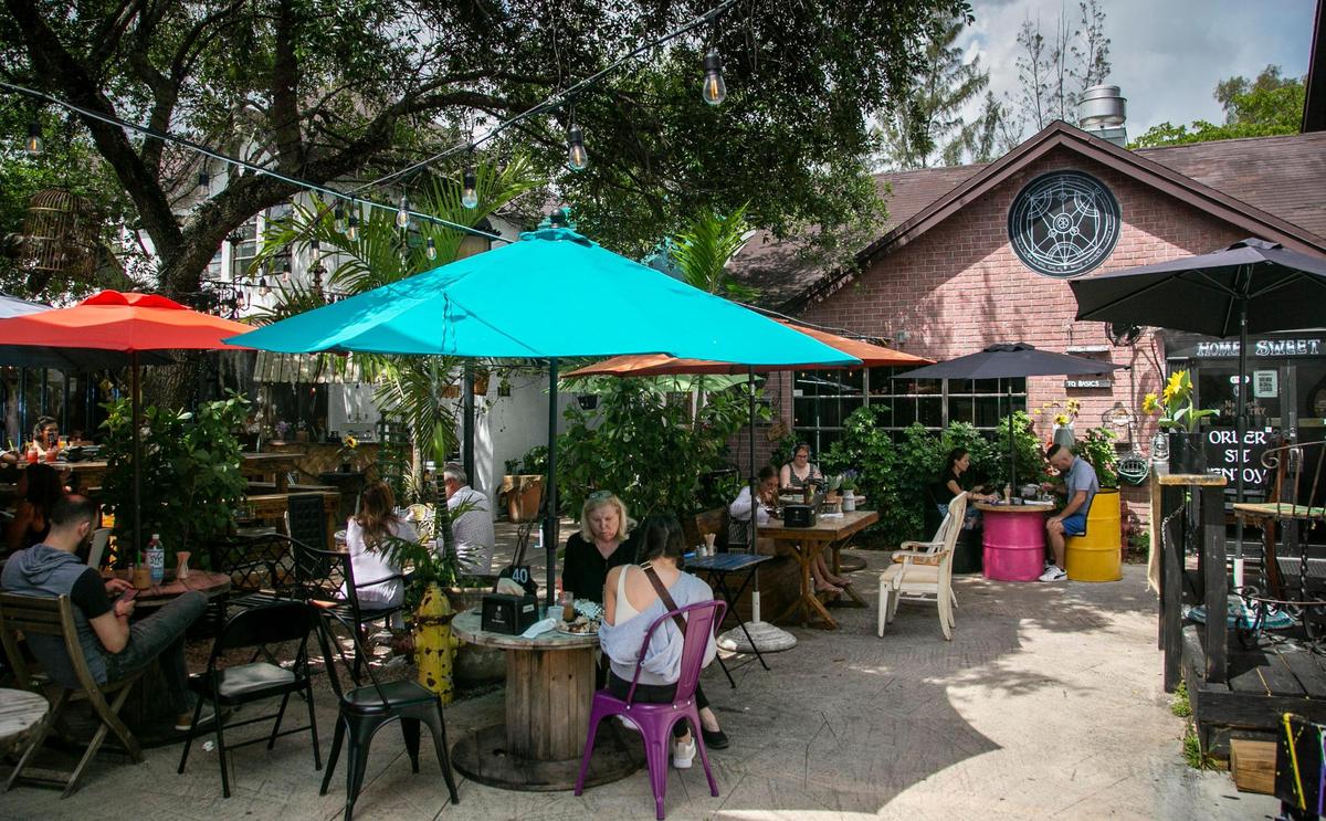 Outdoor seating area and the main building of The Alchemist.