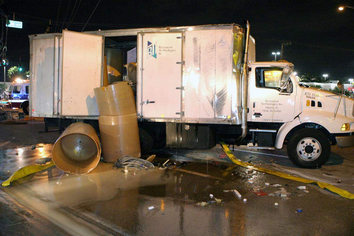 Crews clean up empty drums after a truck spilled a load of canola cooking oil in 2004 on Commercial Boulevard just east of Dixie Highway in Broward County.