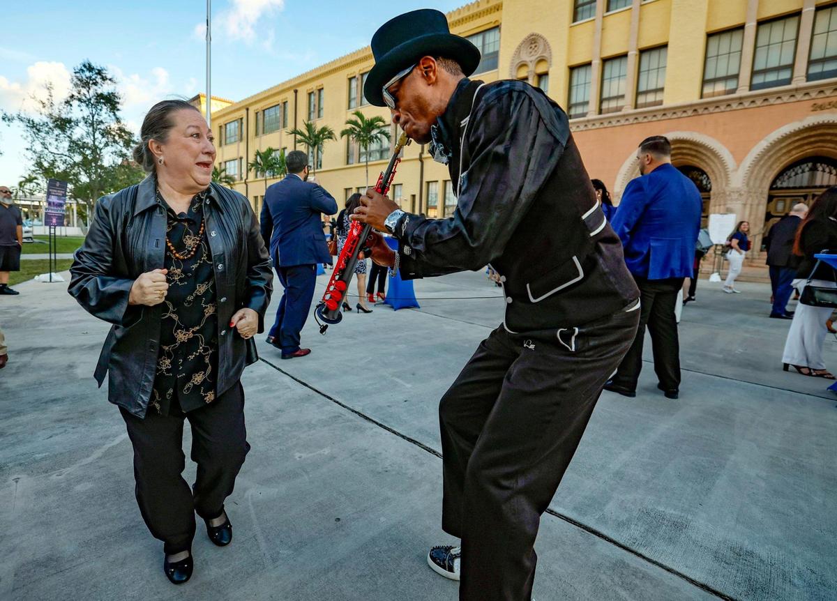 Bertha Morales dances as Jon Sax performs for early arrivals for the annual State of the County address by Miami-Dade Mayor Daniella Levine Cava in Miami, Florida on Thursday, January 30, 2025.