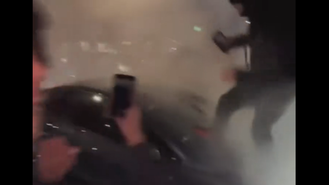 Spectators were seen jumping on hoods and attempting to stomp out the windshield of cars stuck in traffic, video shows.