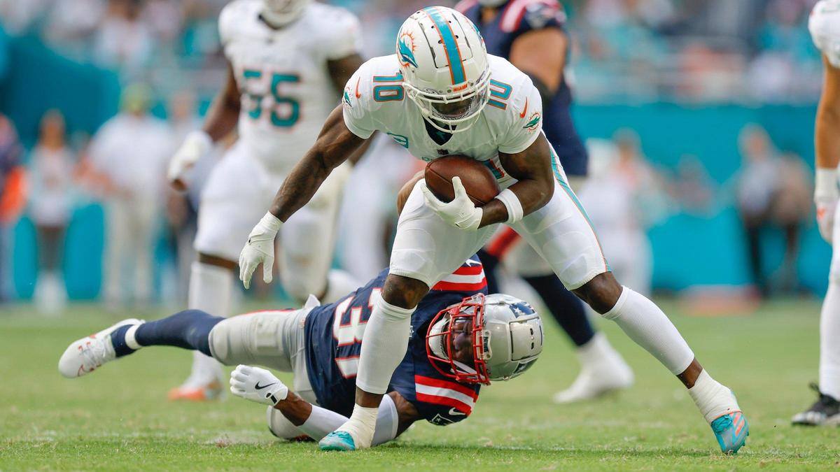 Miami Dolphins wide receiver Tyreek Hill (10) attempts top break a tackle by New England Patriots cornerback Jonathan Jones (31) in the first half during their NFL football game at Hard Rock Stadium in Miami Gardens, Florida, on Sunday, November 24, 2024.
